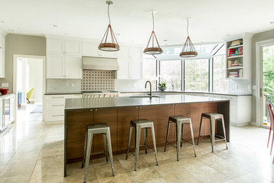Inspiration for a huge contemporary u-shaped travertine floor eat-in kitchen remodel in Portland with an undermount sink, recessed-panel cabinets, white cabinets, granite countertops, multicolored backsplash, porcelain backsplash, stainless steel appliances and an island