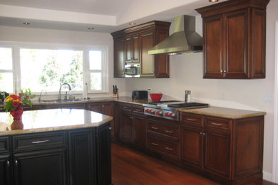 Large elegant u-shaped dark wood floor open concept kitchen photo in San Francisco with an undermount sink, recessed-panel cabinets, dark wood cabinets, granite countertops, stainless steel appliances and an island