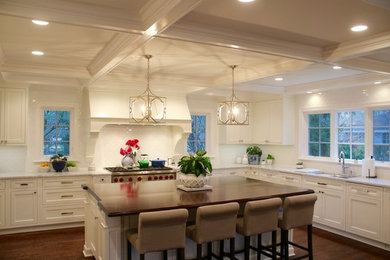 Example of a mid-sized classic l-shaped medium tone wood floor kitchen design in Chicago with an undermount sink, recessed-panel cabinets, white cabinets, wood countertops, white backsplash, subway tile backsplash, stainless steel appliances and an island