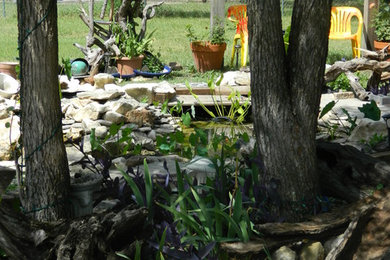 This is an example of a mid-sized eclectic full sun side yard stone water fountain landscape in Austin.