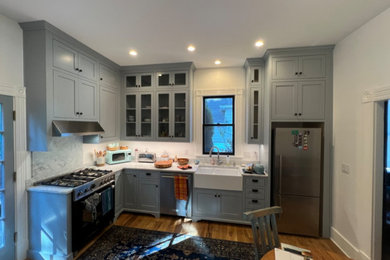 Mid-sized arts and crafts light wood floor eat-in kitchen photo in Portland with a farmhouse sink, shaker cabinets, gray cabinets, marble countertops, white backsplash, marble backsplash, stainless steel appliances and white countertops