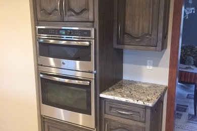 Inspiration for a large timeless enclosed kitchen remodel in Other with stainless steel appliances, an undermount sink, raised-panel cabinets, dark wood cabinets, granite countertops and an island