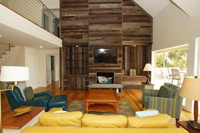 Example of a large mountain style formal and open concept medium tone wood floor and brown floor living room design with white walls, a standard fireplace, a wood fireplace surround and a wall-mounted tv