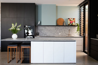Inspiration for a mid-sized open plan kitchen in Melbourne with an undermount sink, white cabinets, marble benchtops, grey splashback, marble splashback, black appliances, concrete floors, grey floor, grey benchtop, with island and flat-panel cabinets.