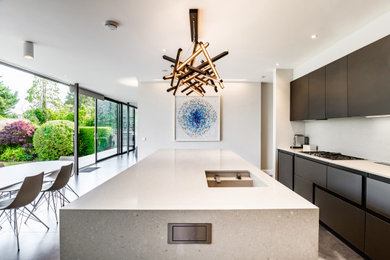 Design ideas for an expansive modern l-shaped kitchen in London with glass-front cabinets, brown cabinets, composite countertops, integrated appliances, porcelain flooring, an island, brown floors, beige worktops and feature lighting.
