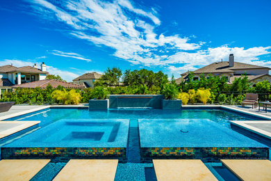 Inspiration for a huge contemporary backyard rectangular hot tub remodel in Austin with decking