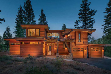 Large mountain style two-story wood exterior home photo in Sacramento with a shed roof