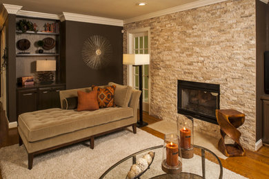 Example of a mid-sized transitional enclosed medium tone wood floor family room design in Raleigh with brown walls, a two-sided fireplace, a stone fireplace and a media wall