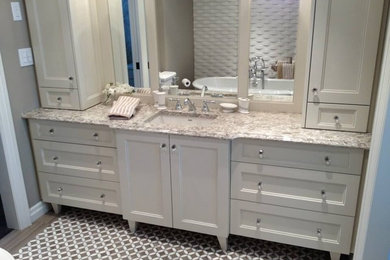 Design ideas for a mid-sized transitional master bathroom in Toronto with recessed-panel cabinets, beige cabinets, a claw-foot tub, grey walls, porcelain floors, an undermount sink, granite benchtops and multi-coloured floor.