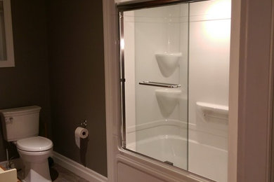 Inspiration for a mid-sized transitional master vinyl floor and multicolored floor bathroom remodel in Other with recessed-panel cabinets, medium tone wood cabinets, a two-piece toilet, gray walls, laminate countertops and yellow countertops