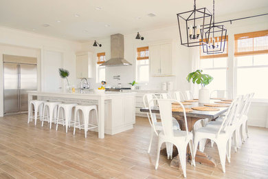 Inspiration for a mid-sized transitional l-shaped medium tone wood floor and brown floor eat-in kitchen remodel in Miami with an undermount sink, shaker cabinets, white cabinets, quartz countertops, white backsplash, subway tile backsplash, stainless steel appliances and an island