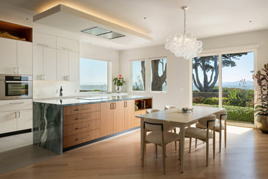 Large minimalist kitchen photo in San Francisco with flat-panel cabinets, white backsplash, porcelain backsplash, an island and blue countertops