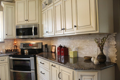 Eat-in kitchen - mid-sized traditional l-shaped medium tone wood floor and brown floor eat-in kitchen idea in Philadelphia with an undermount sink, raised-panel cabinets, white cabinets, granite countertops, beige backsplash, stainless steel appliances and an island
