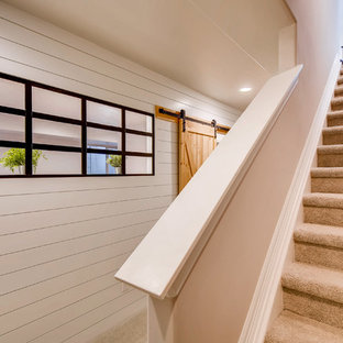 This is an example of a large farmhouse fully buried basement in Denver with white walls, laminate floors, no fireplace and brown floors.