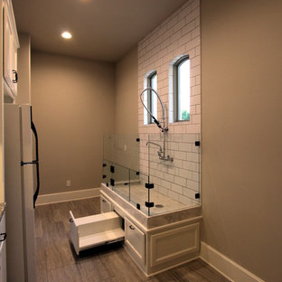 オースティンの大きい片開きドア地中海スタイルのおしゃれなマッドルーム (ベージュの壁、ラミネートの床、白いドア、ベージュの床) の写真