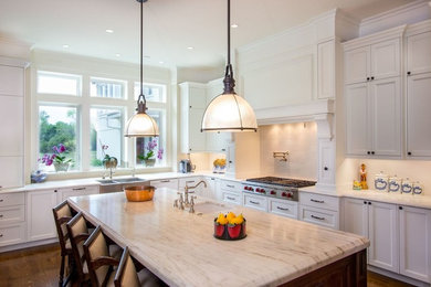 Kitchen pantry - large contemporary l-shaped medium tone wood floor and brown floor kitchen pantry idea in Other with a farmhouse sink, shaker cabinets, white cabinets, marble countertops, white backsplash, subway tile backsplash, stainless steel appliances and an island
