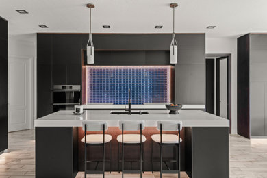 Trendy l-shaped gray floor kitchen photo in Orlando with an undermount sink, flat-panel cabinets, gray cabinets, blue backsplash, mosaic tile backsplash, stainless steel appliances, an island and white countertops