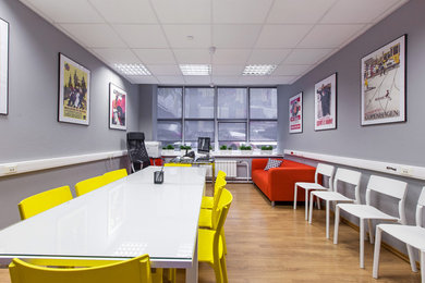Modelo de despacho actual pequeño con paredes grises, suelo laminado, escritorio independiente y suelo marrón