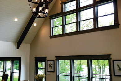 Photo of a large country loft-style living room in Philadelphia with white walls, dark hardwood floors, a standard fireplace, a stone fireplace surround and brown floor.
