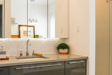 Mid-sized trendy master gray tile and porcelain tile porcelain tile bathroom photo in Ottawa with flat-panel cabinets, gray cabinets, a two-piece toilet, white walls, an undermount sink and quartzite countertops