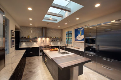 Eat-in kitchen - large contemporary galley travertine floor eat-in kitchen idea in Santa Barbara with a farmhouse sink, flat-panel cabinets, dark wood cabinets, quartz countertops, multicolored backsplash, porcelain backsplash, stainless steel appliances and an island