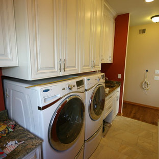 ミルウォーキーの小さいモダンスタイルのおしゃれな家事室 (アンダーカウンターシンク、レイズドパネル扉のキャビネット、白いキャビネット、御影石カウンター、磁器タイルの床、赤い壁、左右配置の洗濯機・乾燥機) の写真