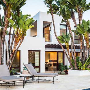 Modern inredning av ett vitt hus, med två våningar, stuckatur och platt tak