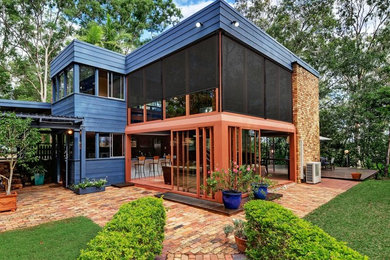 Example of a large trendy red two-story brick exterior home design in Denver