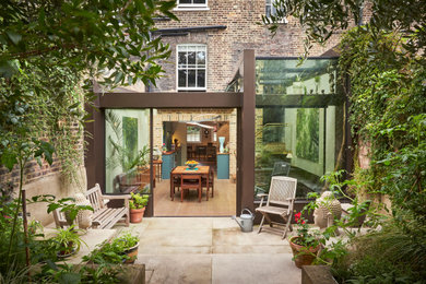 Inspiration for a large contemporary three-storey glass townhouse exterior in London.