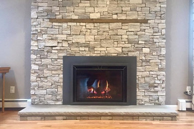 Inspiration for a mid-sized timeless formal light wood floor and brown floor living room remodel in Orange County with gray walls, a standard fireplace and a stone fireplace