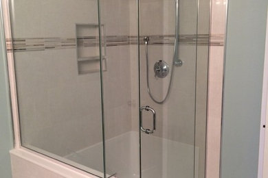 Corner shower - small modern 3/4 porcelain tile corner shower idea in Calgary with blue walls