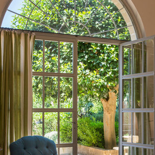 Ejemplo de salón abierto, mediterráneo, grande, con paredes beige, suelo de piedra caliza, chimenea tradicional, marco de chimenea de madera y suelo beige