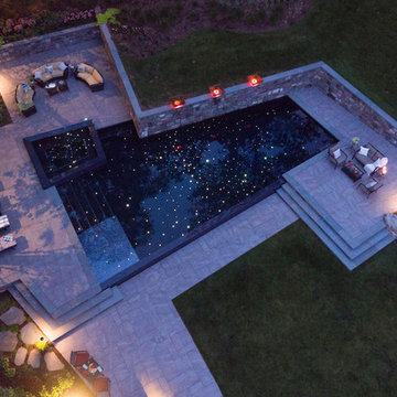 Clean line infinity edge with peremiter overflow spa and detailed stonework