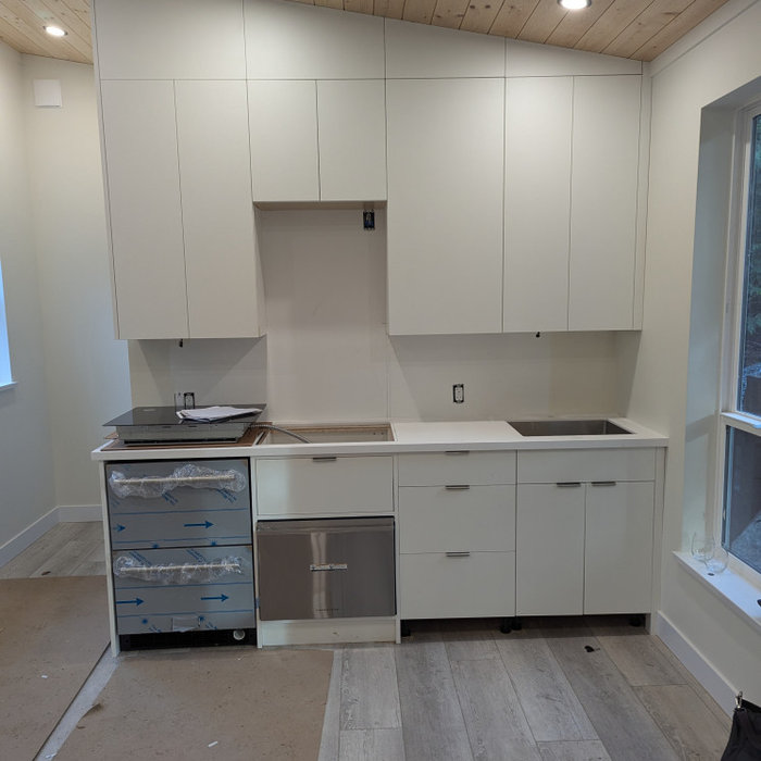 Modern kitchen installation featuring sleek cabinetry, stainless appliances, and white countertops