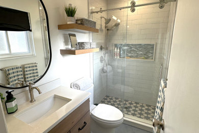Idéer för ett litet klassiskt vit badrum med dusch, med skåp i shakerstil, skåp i mellenmörkt trä, en dusch i en alkov, en toalettstol med hel cisternkåpa, vit kakel, keramikplattor, vita väggar, klinkergolv i porslin, ett undermonterad handfat, bänkskiva i kvarts, grått golv och dusch med skjutdörr