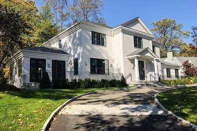 Large transitional white two-story vinyl house exterior photo in New York with a hip roof and a shingle roof