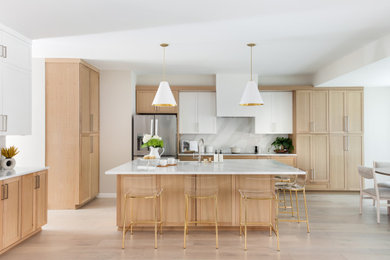 Transitional l-shaped light wood floor and beige floor kitchen photo in Austin with shaker cabinets, light wood cabinets, white backsplash, stone slab backsplash, stainless steel appliances and white countertops
