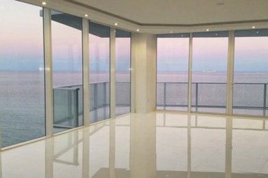 Living room - large contemporary enclosed porcelain tile and beige floor living room idea in Miami with no fireplace