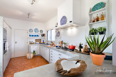 Photo of a traditional open plan kitchen in Other with a double-bowl sink, flat-panel cabinets, white cabinets, white splashback, ceramic flooring, no island and orange floors.