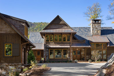 Large rustic brown two-story mixed siding house exterior idea in Other with a gray roof