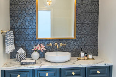 This is an example of a mid-sized transitional 3/4 bathroom in Los Angeles with raised-panel cabinets, blue cabinets, ceramic tile, black walls, limestone floors, a vessel sink, marble benchtops, black floor and white benchtops.