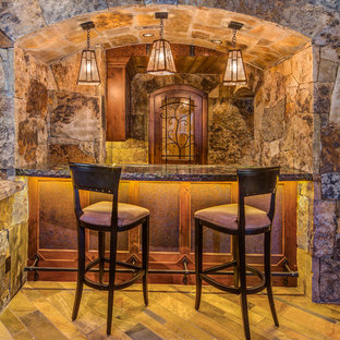 デンバーの中サイズのラスティックスタイルのおしゃれな着席型バー (落し込みパネル扉のキャビネット、濃色木目調キャビネット、合板フローリング) の写真