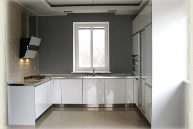 Идея дизайна: п-образная кухня среднего размера в современном стиле с обеденным столом, врезной мойкой, плоскими фасадами, белыми фасадами, столешницей из ламината и белой столешницей