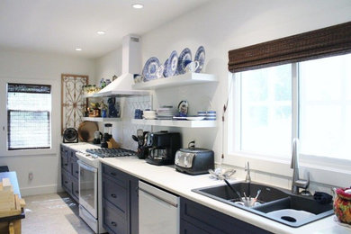 Photo of a large transitional galley eat-in kitchen in Other with a double-bowl sink, shaker cabinets, blue cabinets, white splashback, subway tile splashback, white appliances, with island, white benchtop, laminate benchtops and vinyl floors.