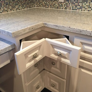 Idée de décoration pour une très grande arrière-cuisine minimaliste en L avec un évier de ferme, un placard avec porte à panneau surélevé, des portes de placard violettes, un plan de travail en granite, une crédence en carreau de verre, un électroménager en acier inoxydable, un sol en bois foncé, un îlot central et un sol marron.