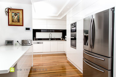 Design ideas for a modern kitchen in Sydney with quartz benchtops, black splashback and glass sheet splashback.