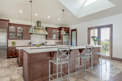Large transitional beige floor kitchen photo in Tampa with a farmhouse sink, recessed-panel cabinets, medium tone wood cabinets, quartz countertops, white backsplash, mosaic tile backsplash, stainless steel appliances and two islands