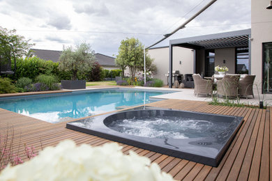 Foto de piscinas y jacuzzis actuales de tamaño medio a medida en patio lateral con entablado