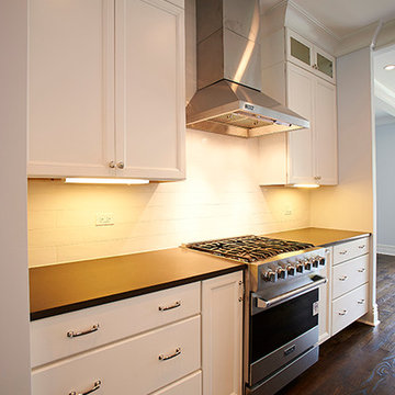 Modern Kitchen with Stainless Steel Range, White Cabinetry, and Dark Countertops