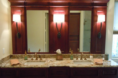 Foto de cuarto de baño principal clásico renovado de tamaño medio con lavabo bajoencimera, armarios con paneles empotrados, puertas de armario de madera oscura y encimera de granito